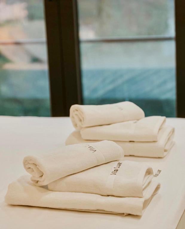 Folded towels by a window in a bathroom at Vila Luar