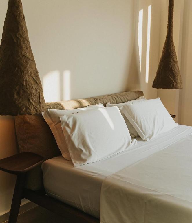 A bedroom at Vila Luar with white linen and soft morning light